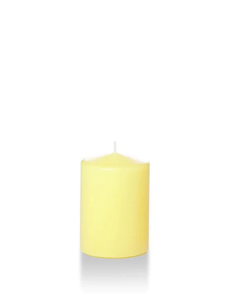 Four inch tall pale yellow coloured pillar candle shown for sale on a white background.